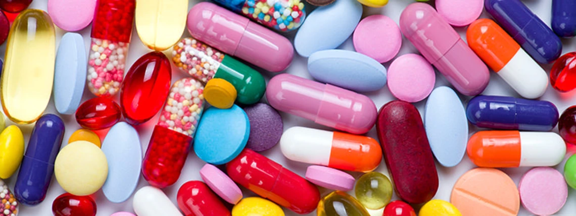 Assorted colorful pills and capsules scattered in a pile.