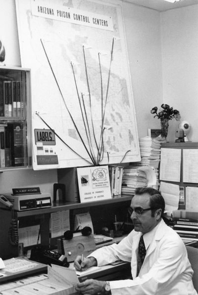 1950 era photo of man at desk with map behind